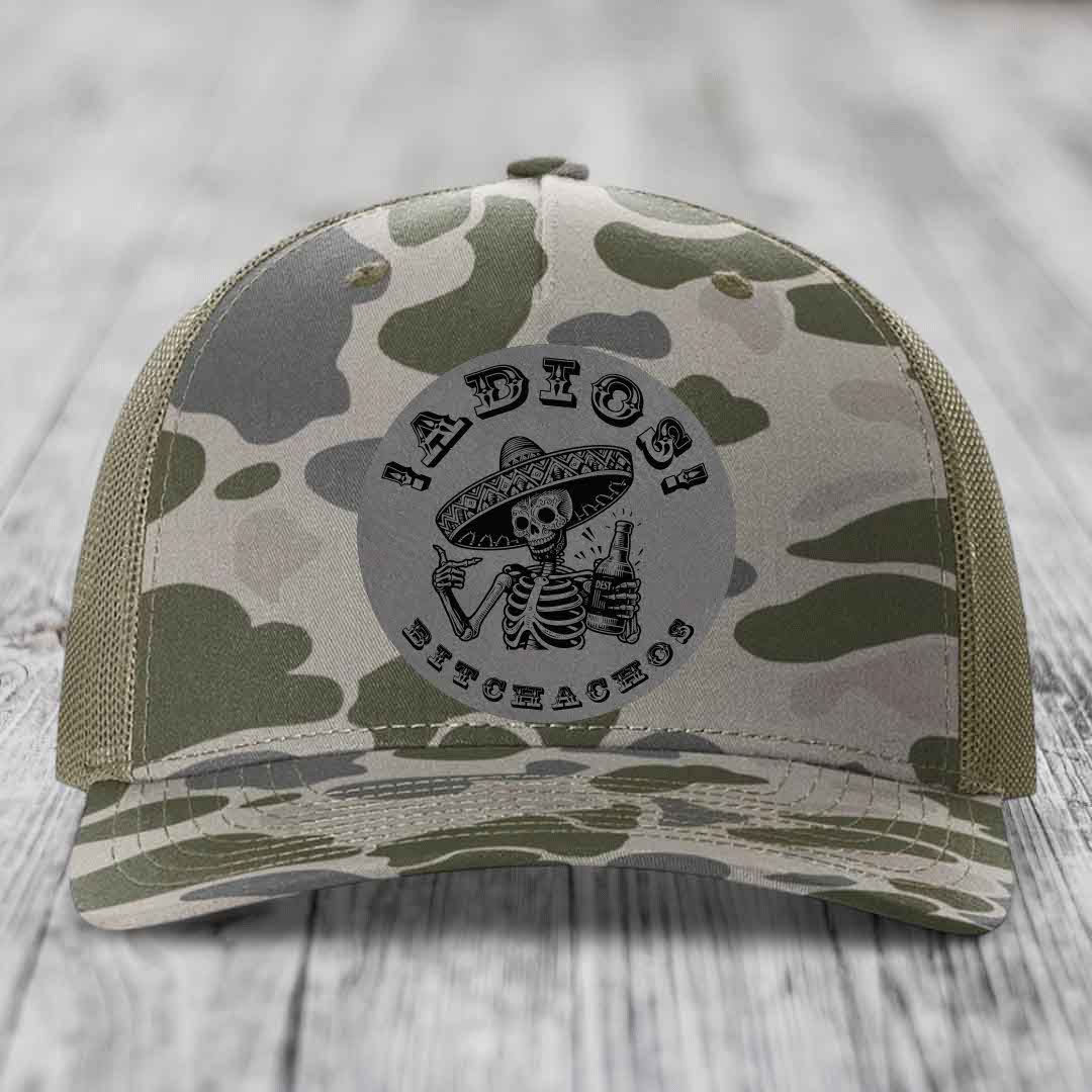 Camouflage trucker hat with skeleton in sombrero patch reading &