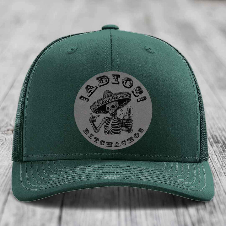 Green trucker hat with a circular patch featuring a skeleton in a sombrero holding a beer bottle, text reads &