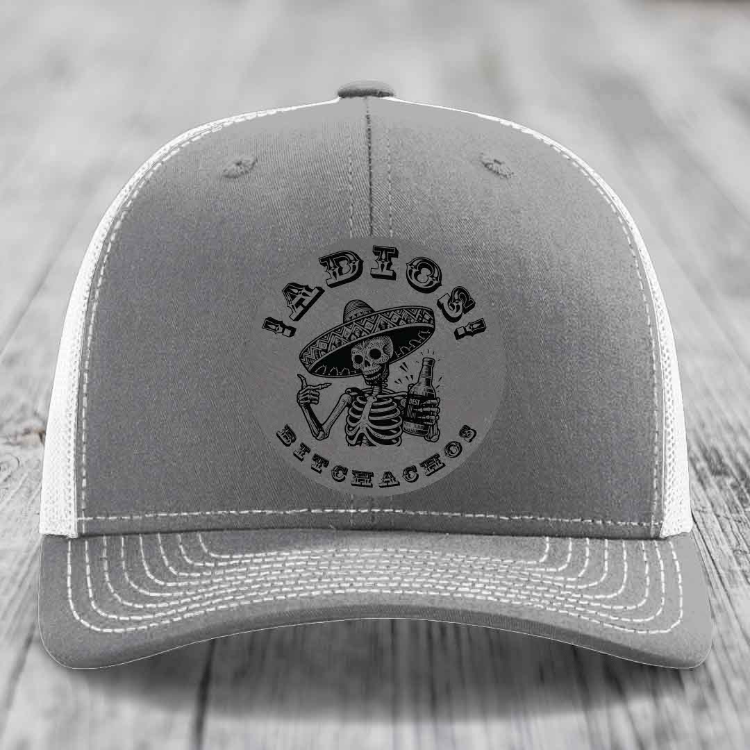 Grey trucker hat with white mesh back and embroidered skull holding beer bottle design.