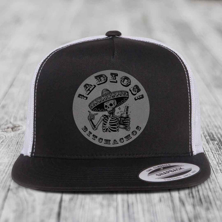 Black and white trucker hat with skeleton wearing sombrero holding beer bottle, text &