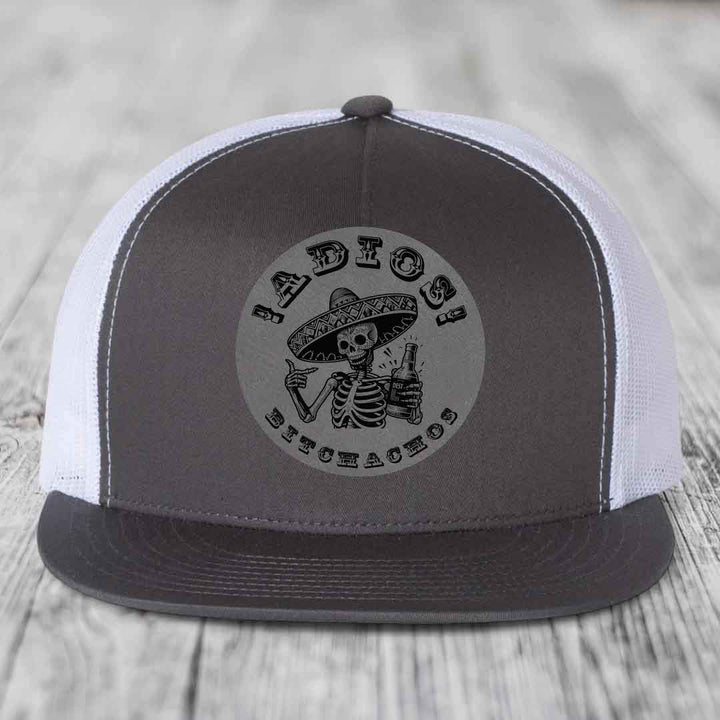 Grey and white trucker hat with skull graphic reading &