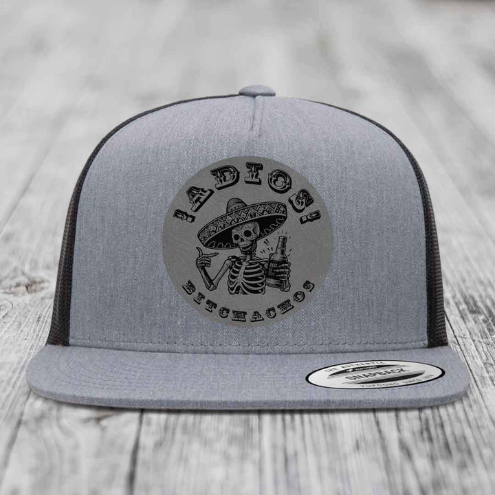 Grey trucker hat with black embroidered patch of skeleton in sombrero holding beer bottle and text &