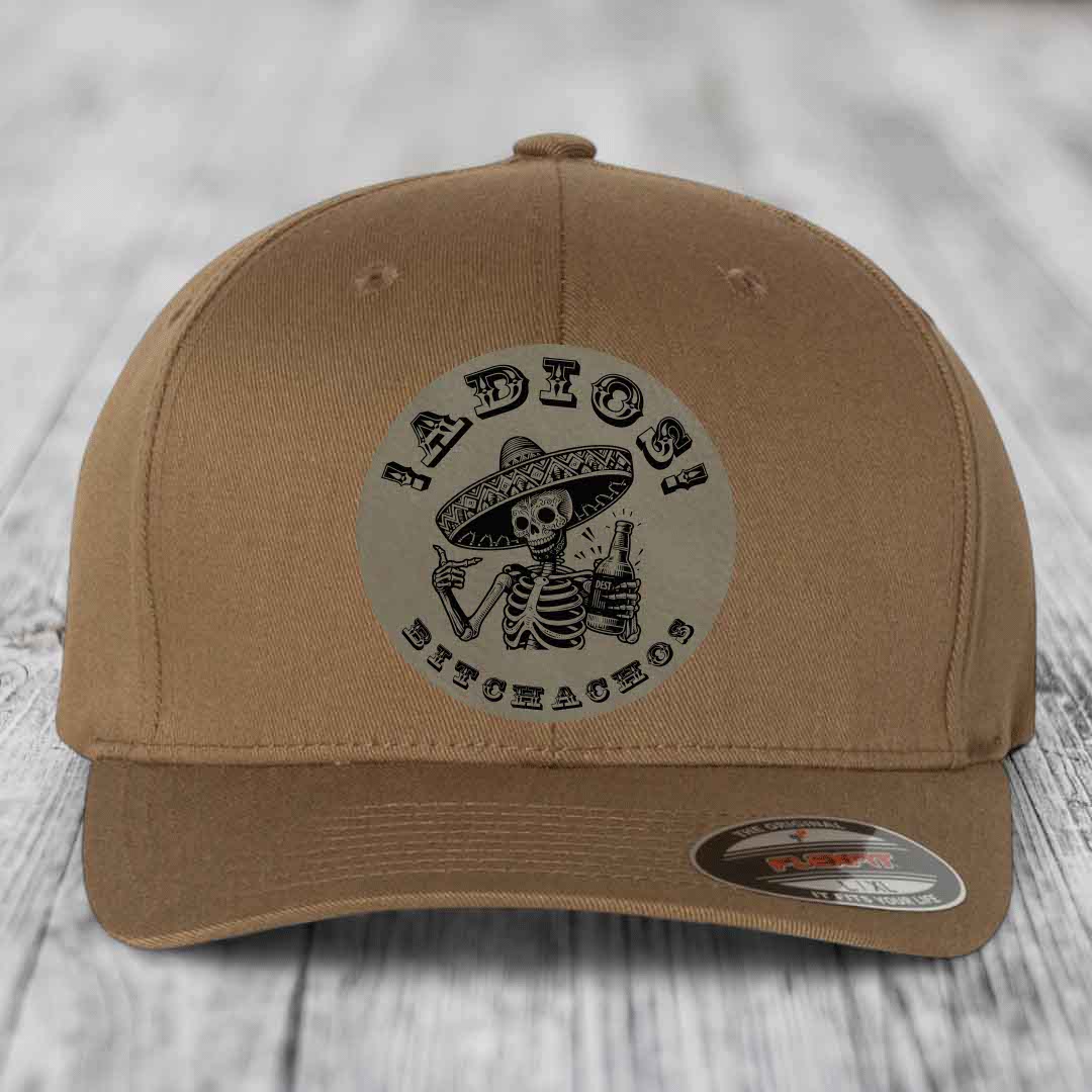 Tan baseball cap with circular skull and sombrero patch reading &