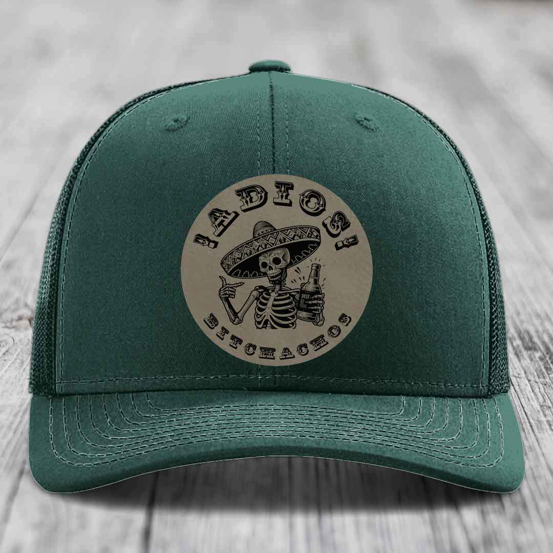 Green trucker hat with a circular patch featuring a skeleton in a sombrero holding a beer bottle and the text &