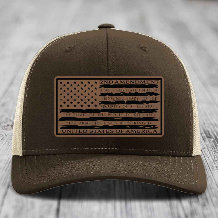 Brown trucker hat with a tan leather patch featuring the American flag and 2nd Amendment text.