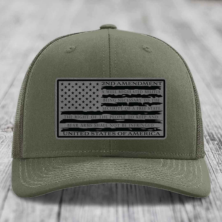 Olive green trucker hat with black 2nd Amendment leather patch featuring American flag design and text.