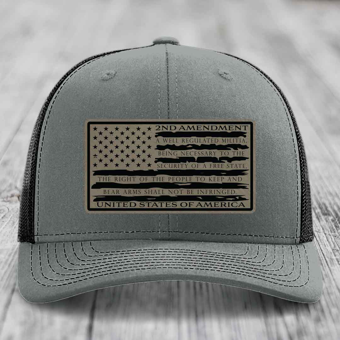 Grey trucker hat with a tan leatherette patch featuring the American flag and 2nd Amendment text.