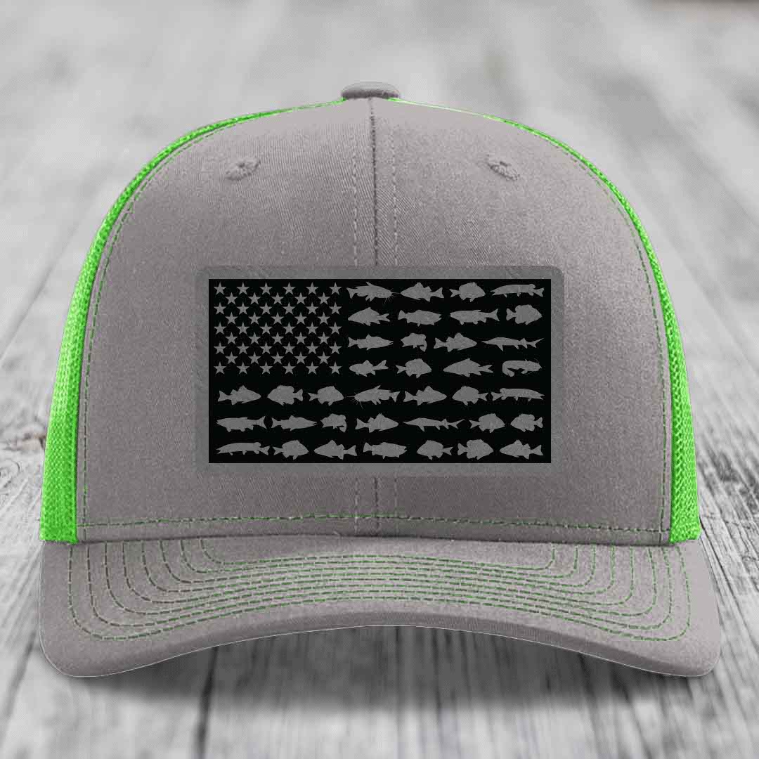 Grey trucker hat with neon green mesh and stitching, featuring a black American flag patch with fish silhouettes instead of stars and stripes.