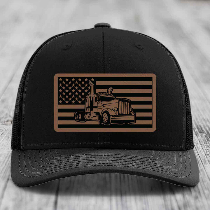Black trucker hat with brown American flag patch featuring a Peterbilt truck silhouette.