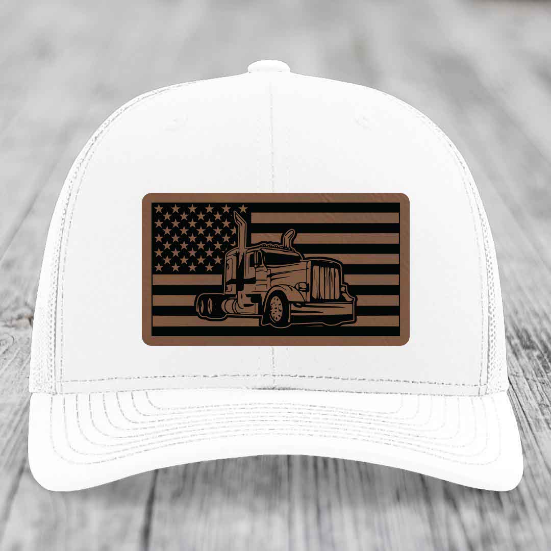 White trucker hat with brown leatherette patch featuring American flag and Peterbilt truck design.