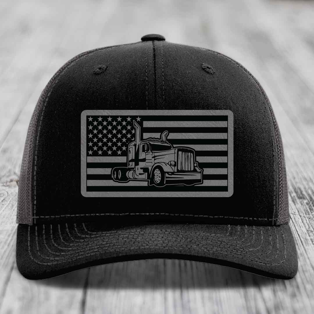 Black trucker hat with American flag patch featuring a Peterbilt truck design.