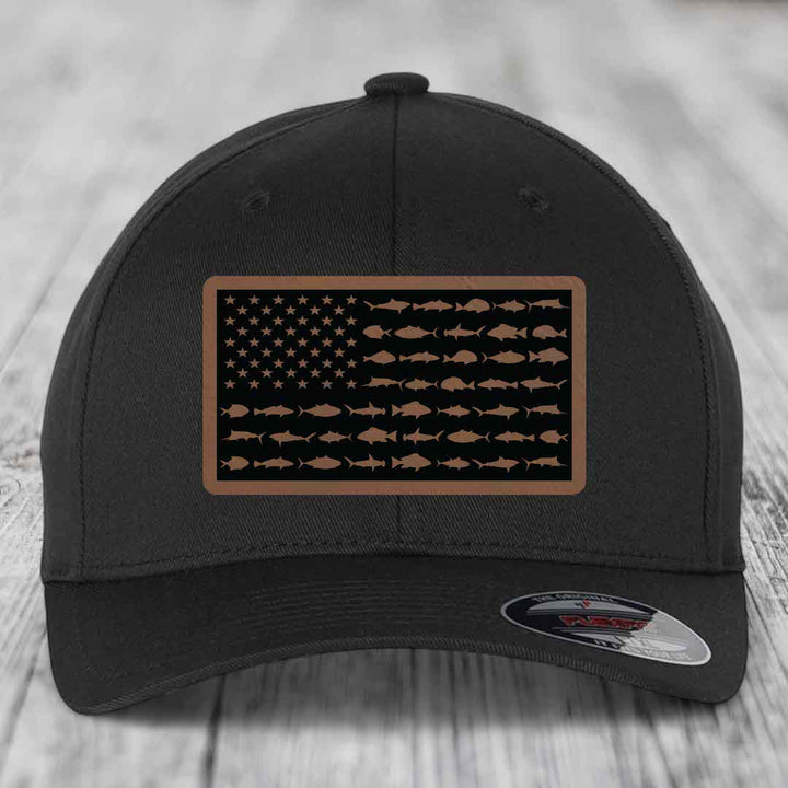 Black baseball cap with a brown leatherette patch featuring an American flag design made of saltwater fish silhouettes.