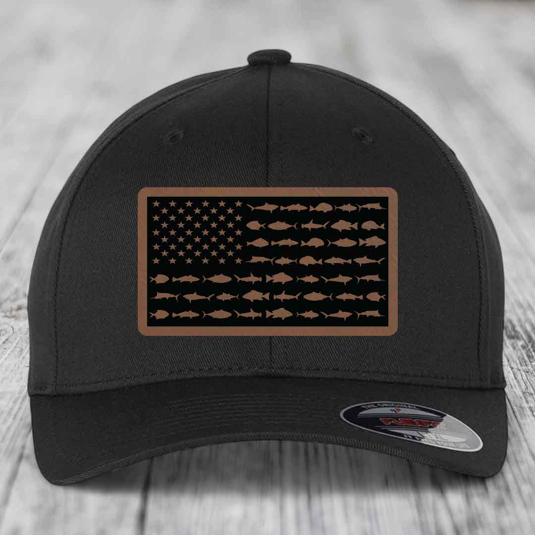 Black baseball cap with a brown leatherette patch featuring an American flag design made of saltwater fish silhouettes.