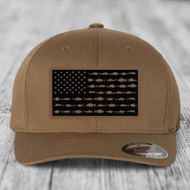 Tan baseball cap with American flag patch made of saltwater fish silhouettes on black background.