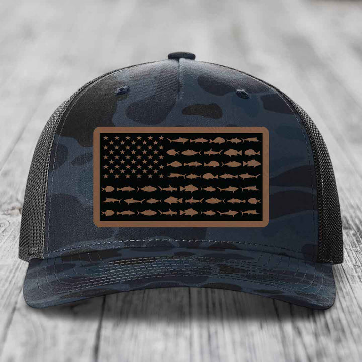 Camouflage trucker hat with American flag patch made of saltwater fish silhouettes.