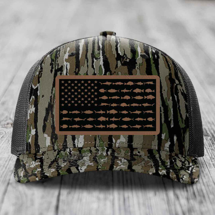 Camouflage trucker hat with American flag patch featuring fish silhouettes instead of stars and stripes.