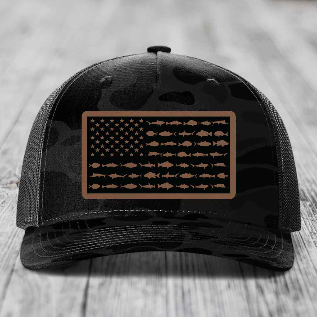 Black camouflage trucker hat with a rectangular patch featuring an American flag design made of fish silhouettes.