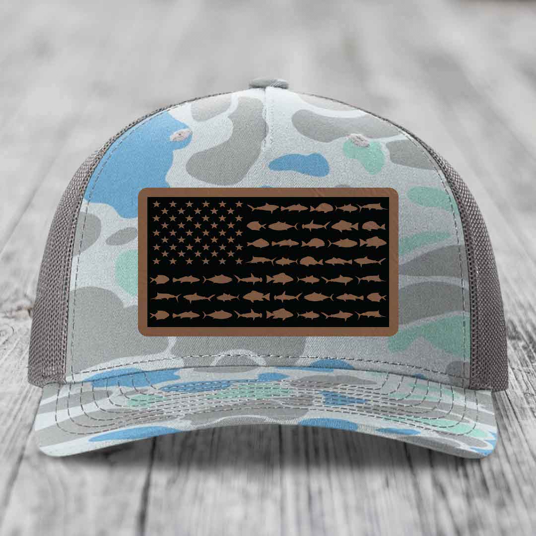 Camouflage trucker hat with American flag patch featuring fish silhouettes instead of stars and stripes.
