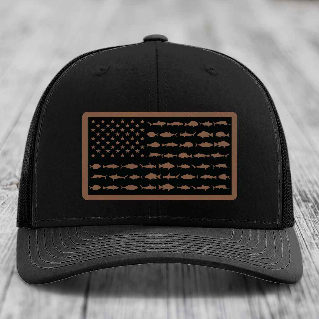 Black trucker hat with a brown leather patch featuring an American flag design made of fish silhouettes.