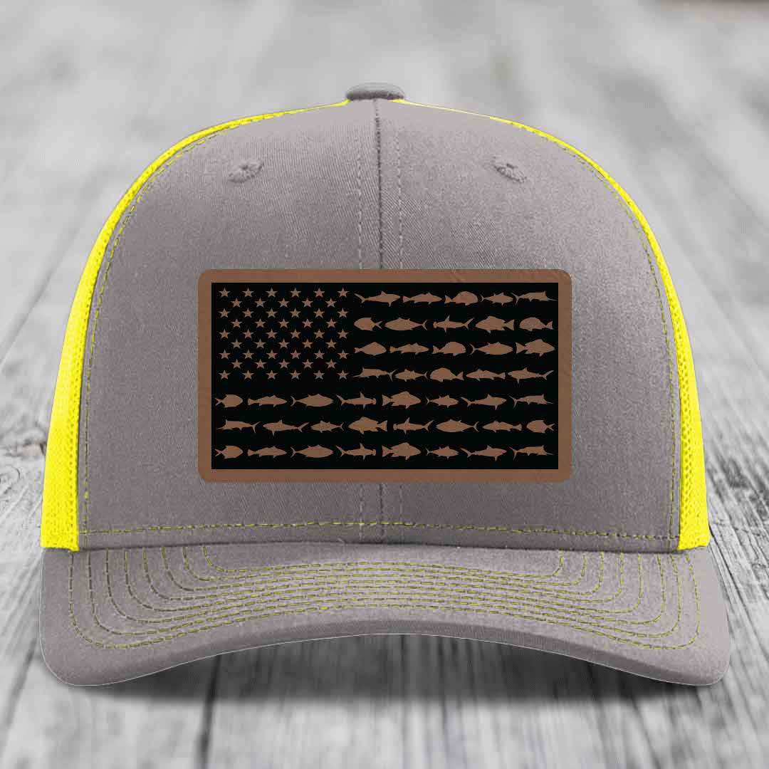 Grey trucker hat with yellow mesh and stitching, featuring a saltwater fish flag patch.
