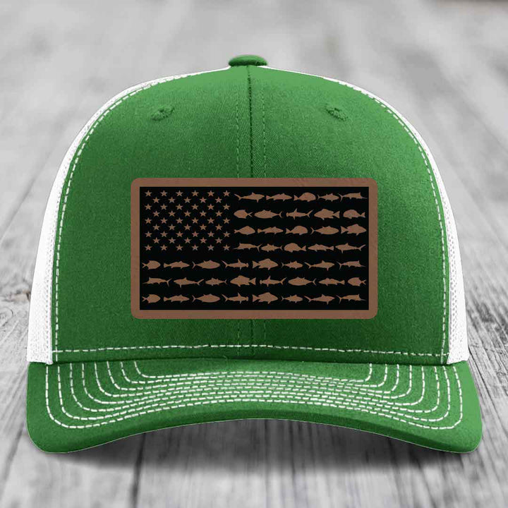 Green trucker hat with white mesh back and stitching, featuring a rectangular patch of an American flag made from fish silhouettes.