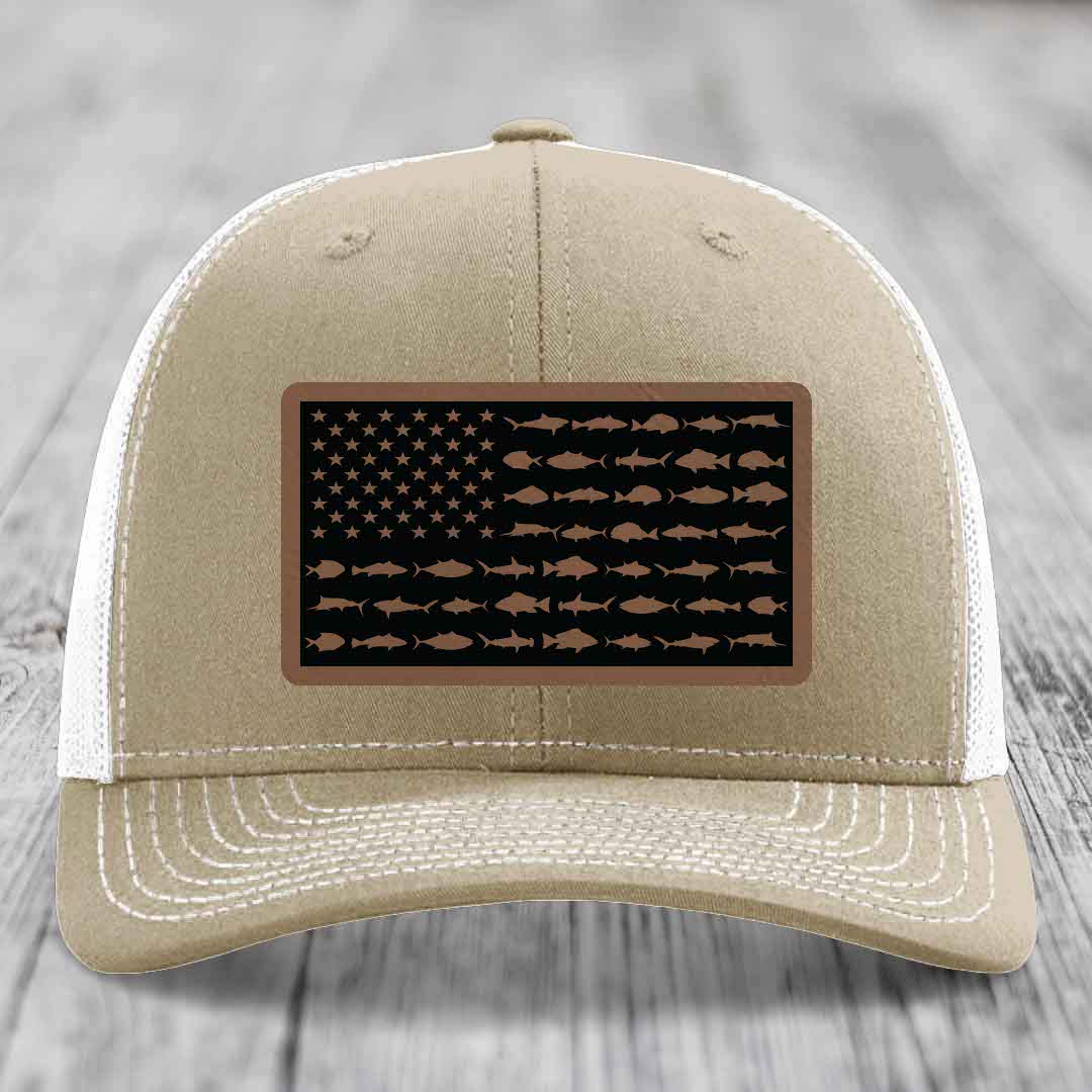 Tan trucker hat with American flag patch made of saltwater fish silhouettes on black background.