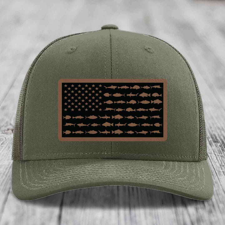 Olive green trucker hat with American flag patch made of saltwater fish silhouettes in brown on black background.