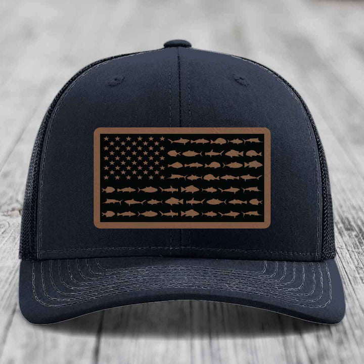 Black trucker hat with a rectangular patch featuring an American flag design made of saltwater fish silhouettes.