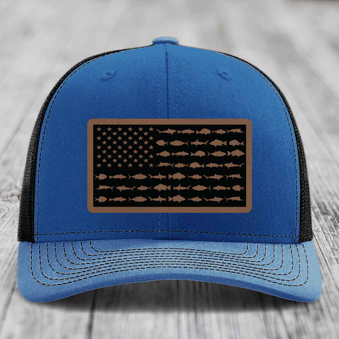 Blue trucker hat with a brown leather patch featuring an American flag design made of fish silhouettes.