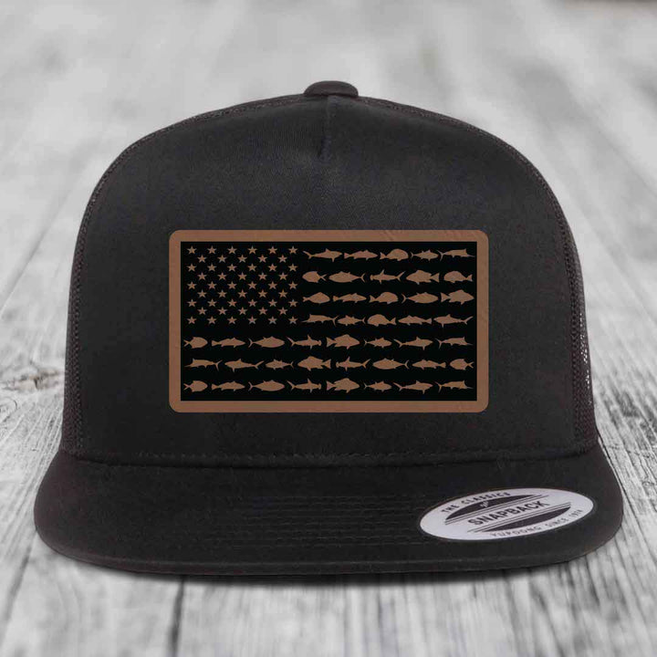 Black trucker hat with a rectangular patch featuring an American flag design made of fish silhouettes.
