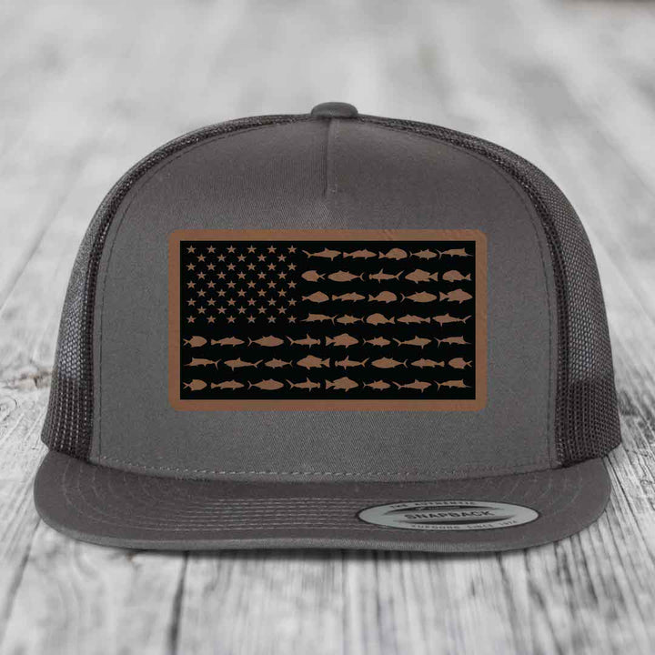 Grey trucker hat with a brown leather patch featuring an American flag design made of fish silhouettes.