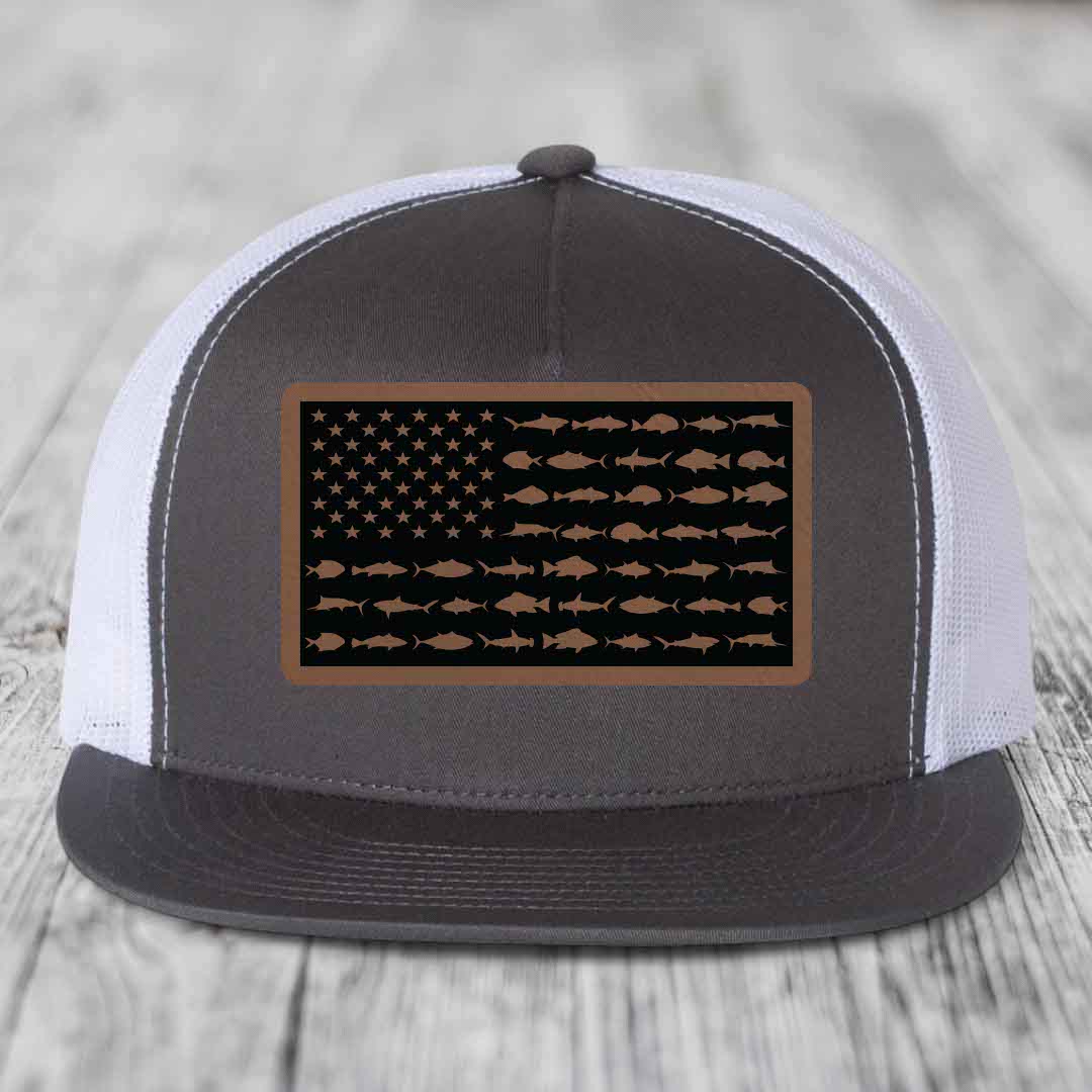 Grey and white trucker hat with a brown leather patch featuring an American flag design made of fish silhouettes.