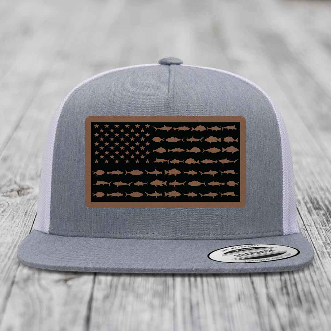 Grey trucker hat with American flag patch made of saltwater fish silhouettes in brown on black background.