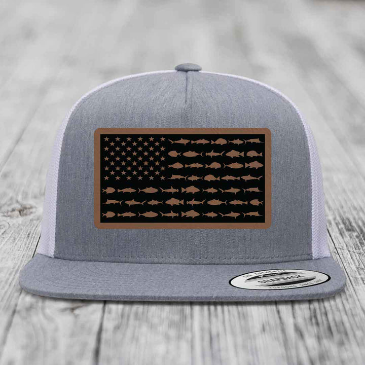 Grey trucker hat with American flag patch made of saltwater fish silhouettes in brown on black background.