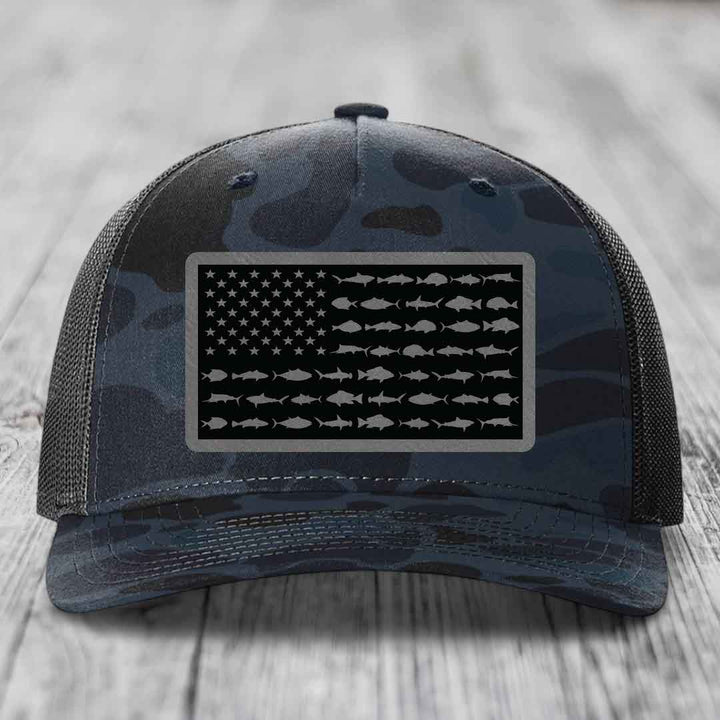 Camouflage trucker hat with American flag patch featuring fish silhouettes instead of stars and stripes.