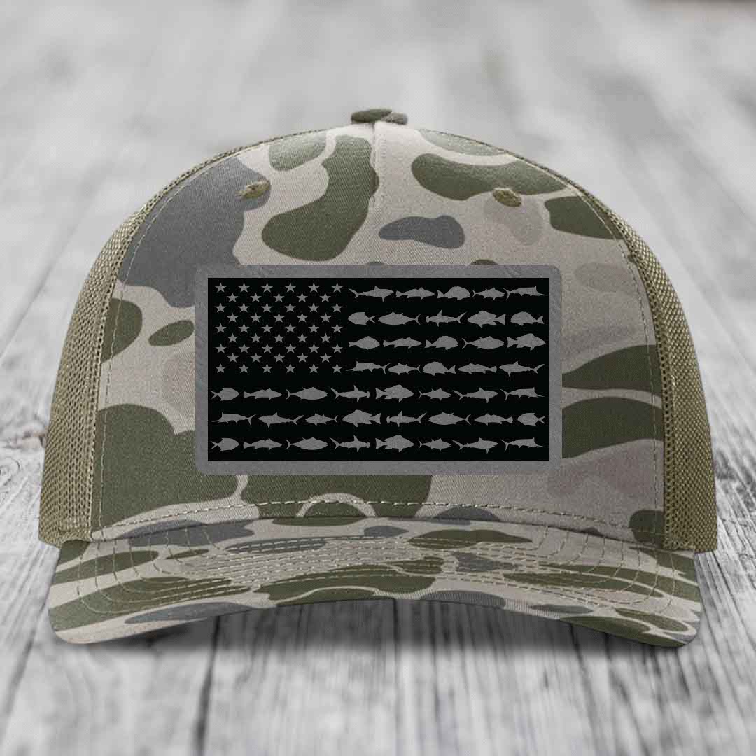 Camouflage trucker hat with American flag patch featuring fish silhouettes instead of stripes.