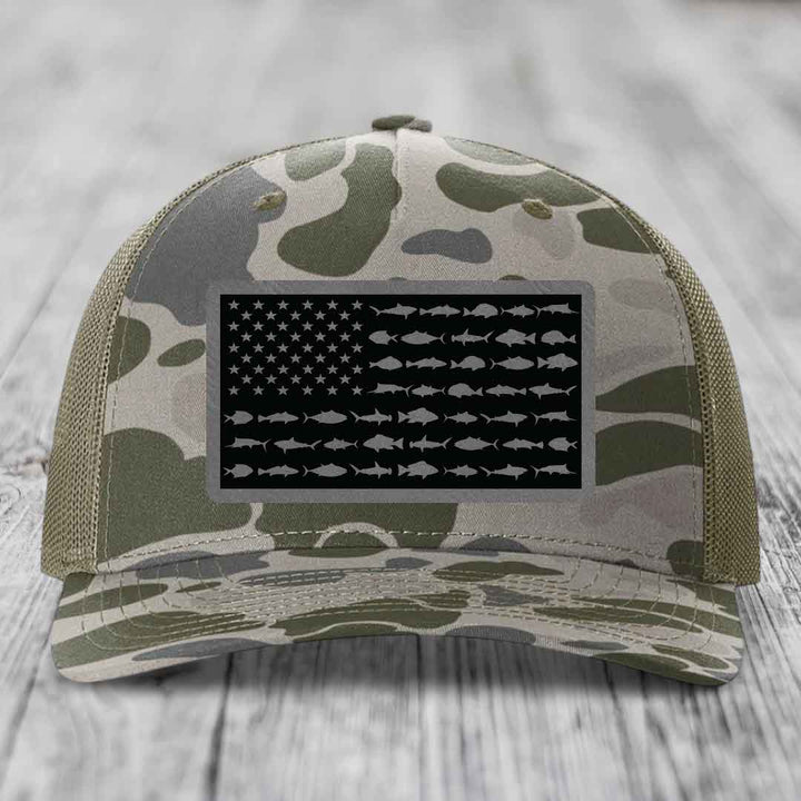 Camouflage trucker hat with American flag patch featuring fish silhouettes instead of stripes.