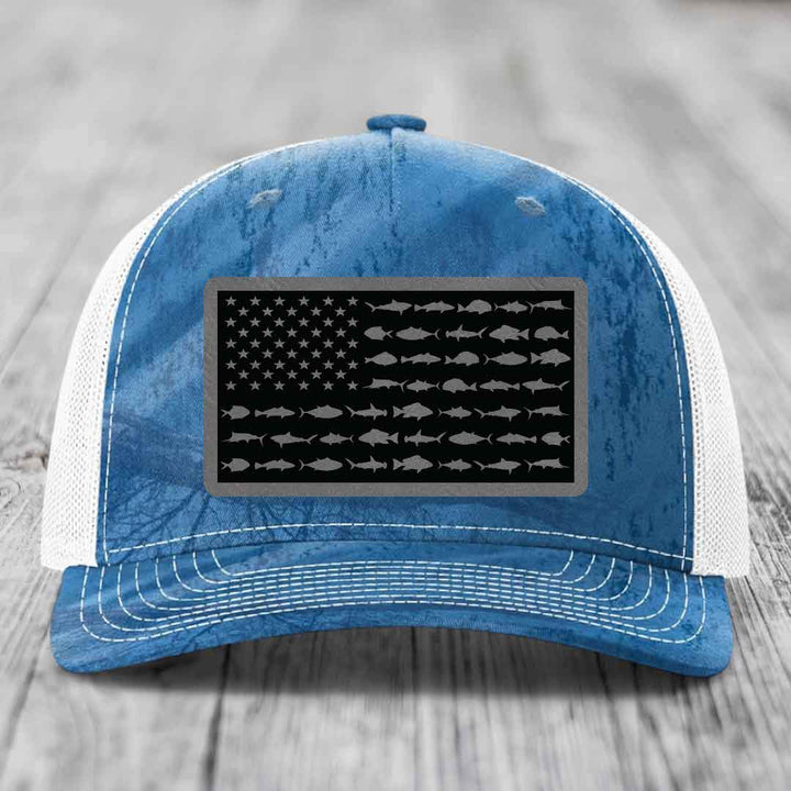 Blue and white trucker hat with American flag patch featuring fish silhouettes instead of stars and stripes.