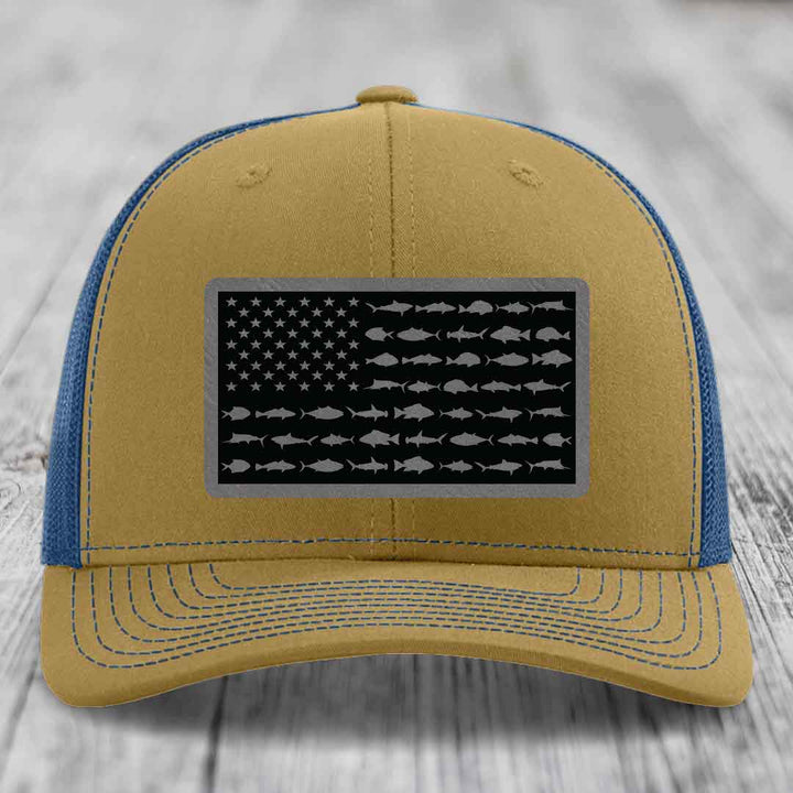Tan and blue trucker hat with American flag patch made of saltwater fish silhouettes.