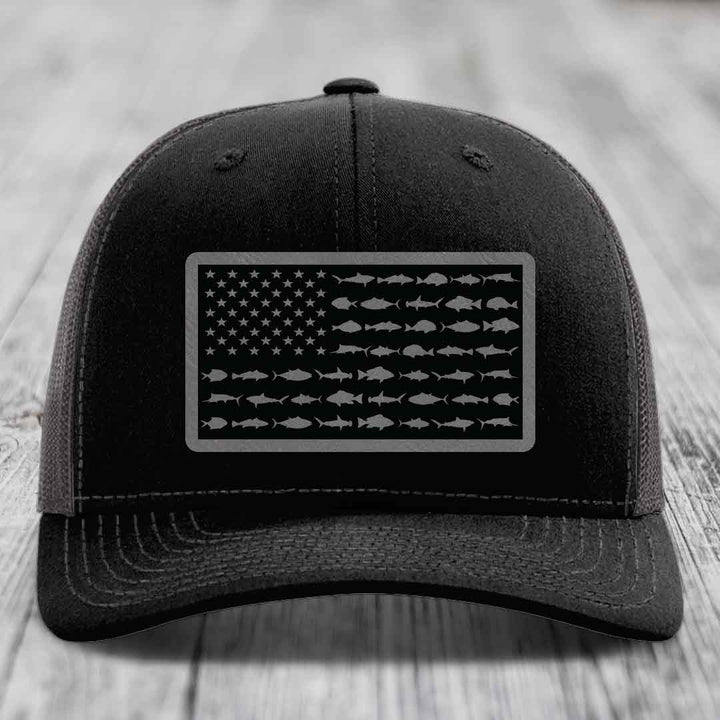 Black trucker hat with American flag patch made of saltwater fish silhouettes.