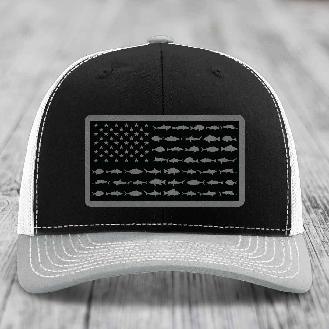 Black and white trucker hat with American flag patch made of saltwater fish silhouettes.