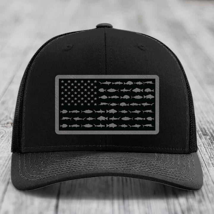 Black trucker hat with American flag patch made of saltwater fish silhouettes.