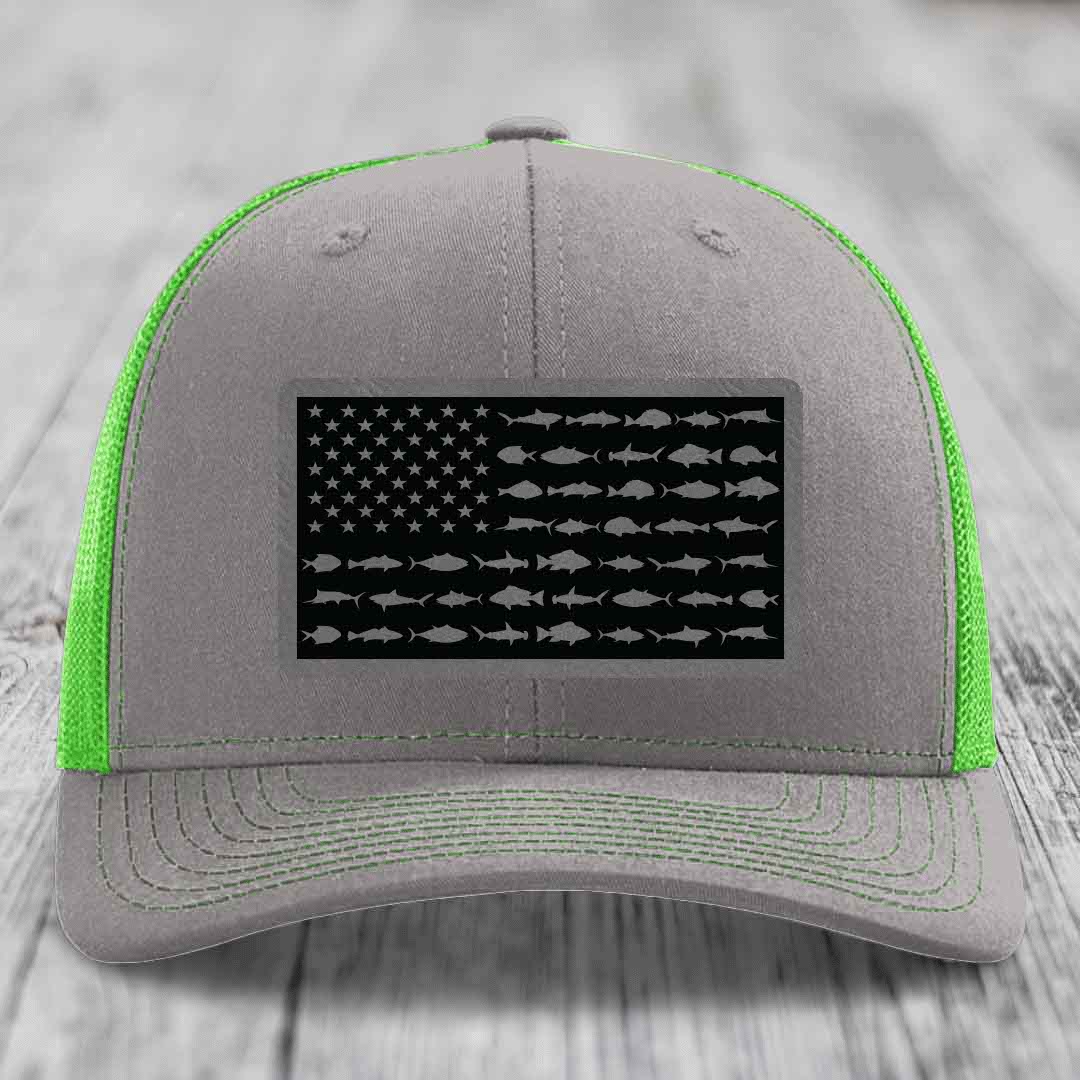 Grey trucker hat with neon green mesh and stitching, featuring a black American flag patch with fish silhouettes.