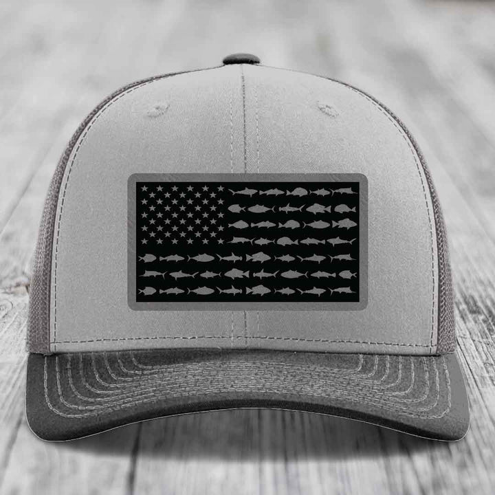 Grey trucker hat with black American flag patch featuring fish silhouettes instead of stars and stripes.