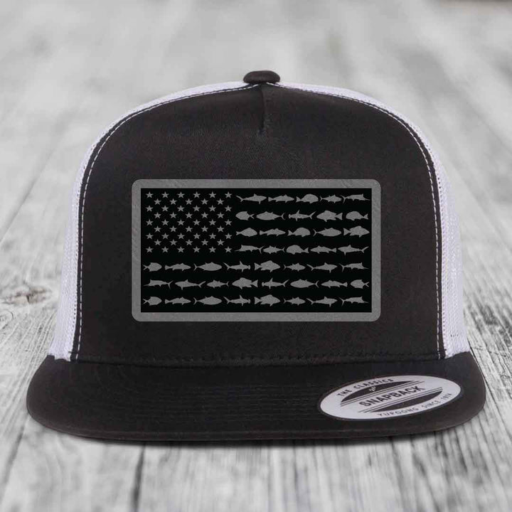 Black and white trucker hat with American flag patch made of saltwater fish silhouettes.