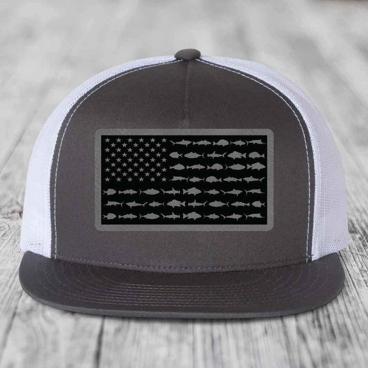 Black and white trucker hat with American flag patch made of saltwater fish silhouettes.