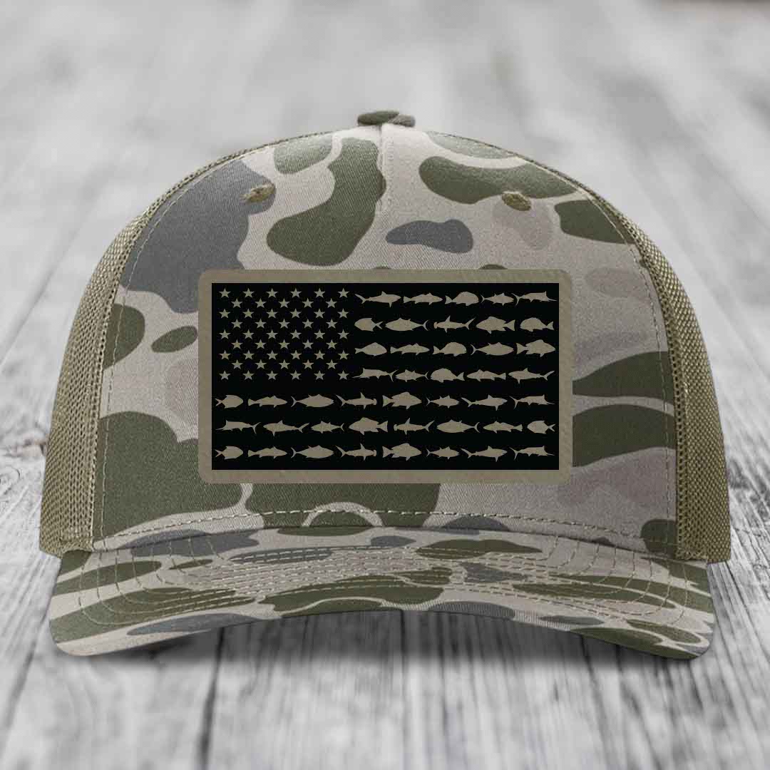 Camouflage trucker hat with American flag patch featuring fish silhouettes instead of stripes.