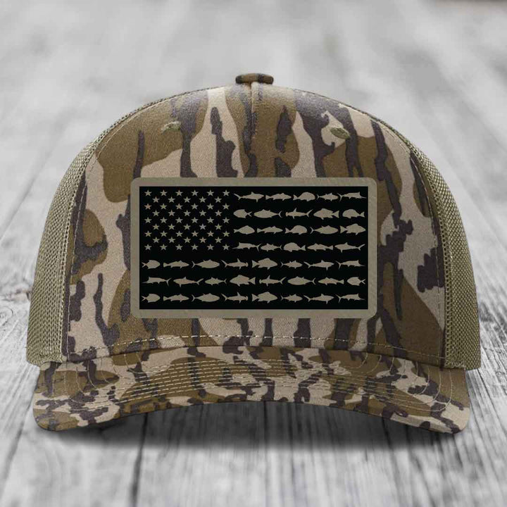 Camouflage trucker hat with American flag patch featuring fish silhouettes instead of stars and stripes.