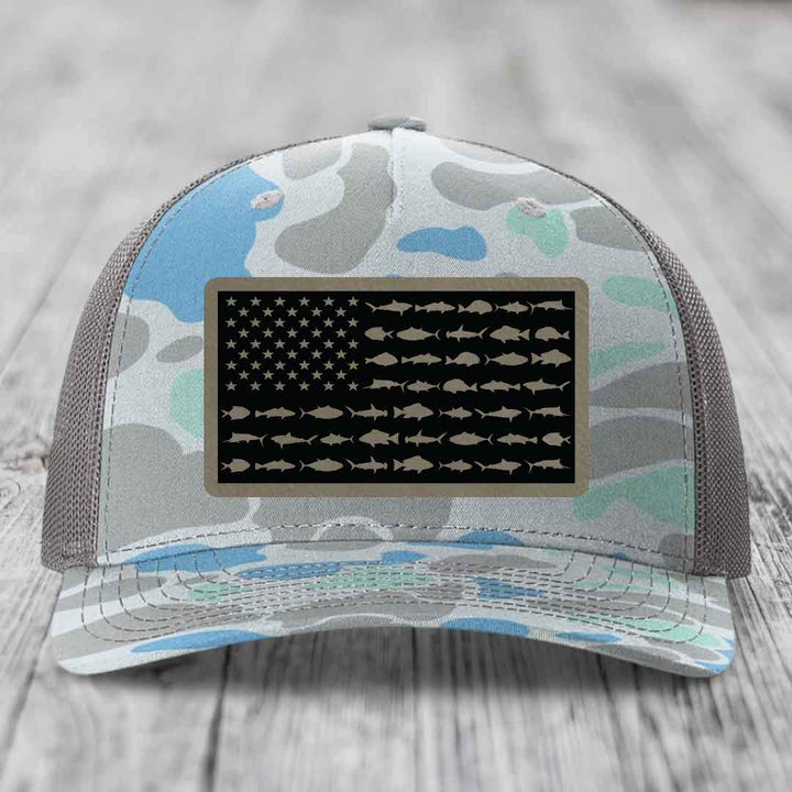 Camouflage trucker hat with American flag patch featuring fish silhouettes instead of stripes.