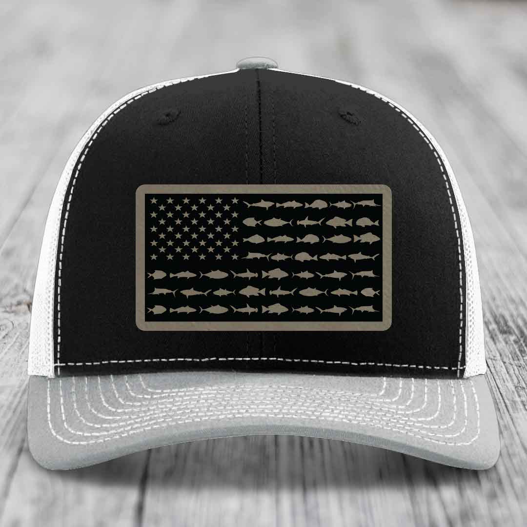 Black and white trucker hat with saltwater fish flag patch on front.